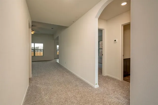 an empty room with a ceiling fan and a window