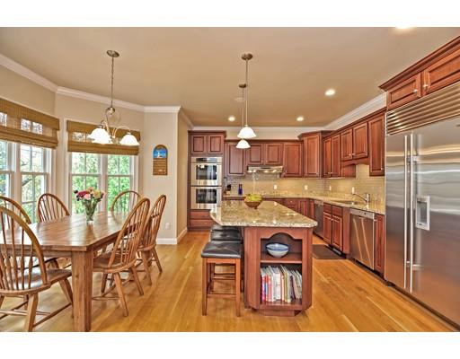 82 Edwardel Road Needham, MA 02492 - Photo 2 of 25 a kitchen with stainless steel appliances granite countertop a refrigerator a microwave oven a dining table and chairs with wooden floor