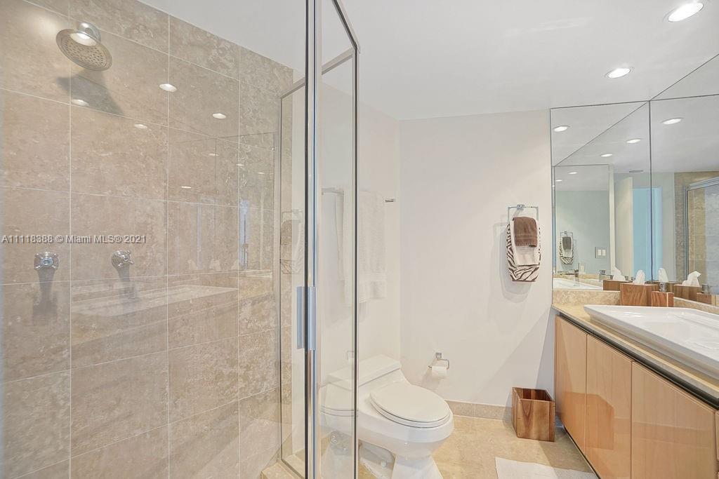 2127 Brickell Avenue, Unit 503 Miami, FL 33129 - Photo 39 of 54 a bathroom with a sink a toilet a mirror and shower