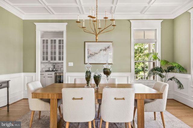 a large white kitchen with granite countertop a stove a refrigerator and a dining table