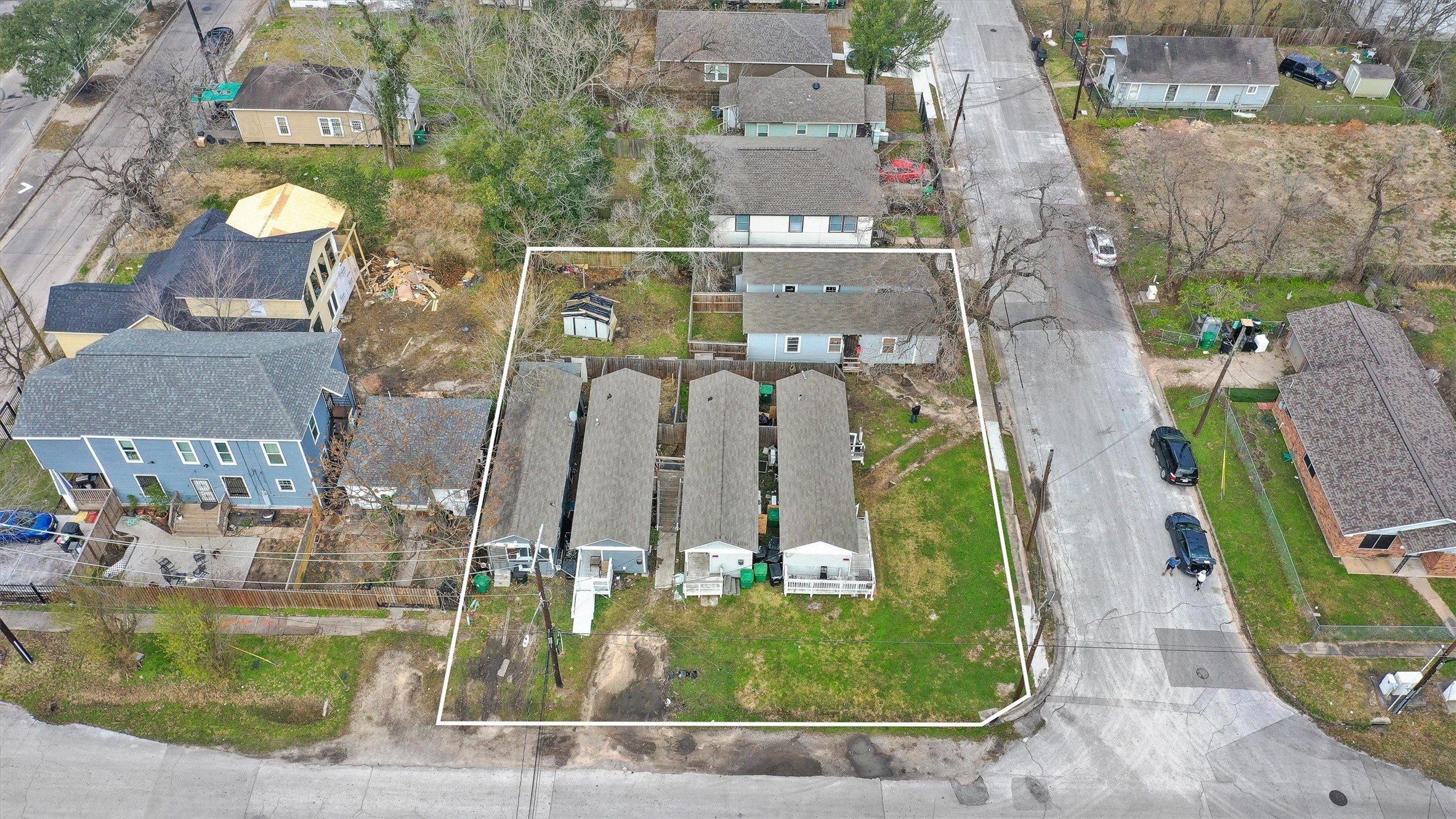 an aerial view of a residential houses with outdoor space and parking