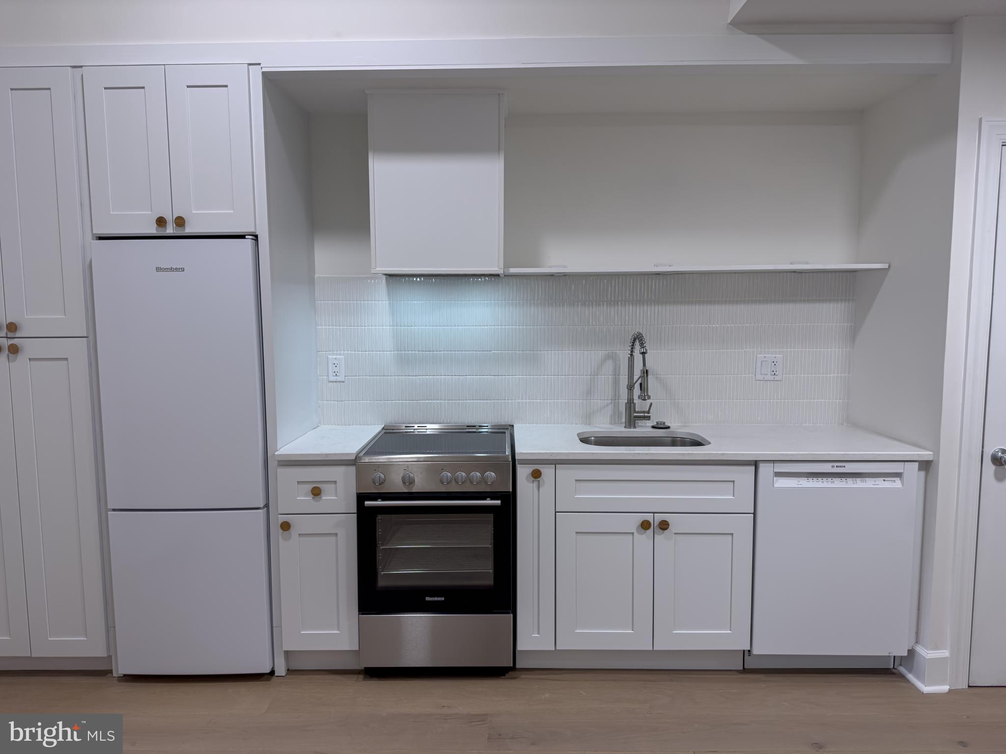 2007 Green Street, Unit 2R Philadelphia, PA 19130 - Photo 6 of 15 a kitchen with white cabinets and stainless steel appliances