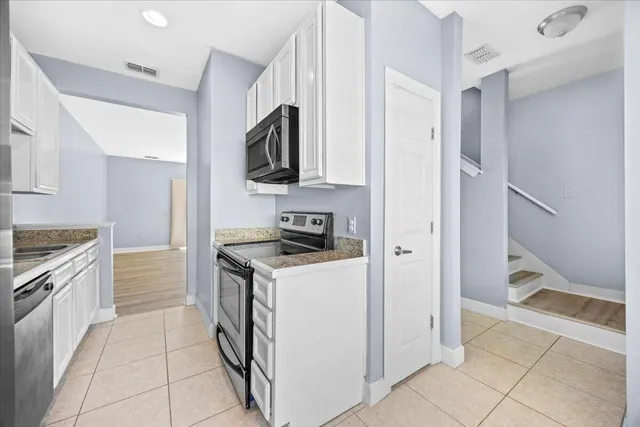 a kitchen with stainless steel appliances granite countertop a stove and a refrigerator