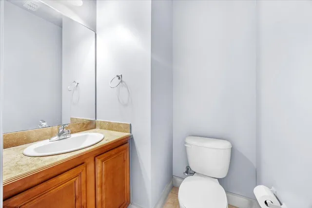 a bathroom with a granite countertop toilet sink and mirror