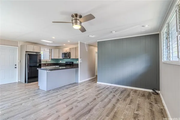 a view of kitchen with stainless steel appliances refrigerator stove microwave and cabinets