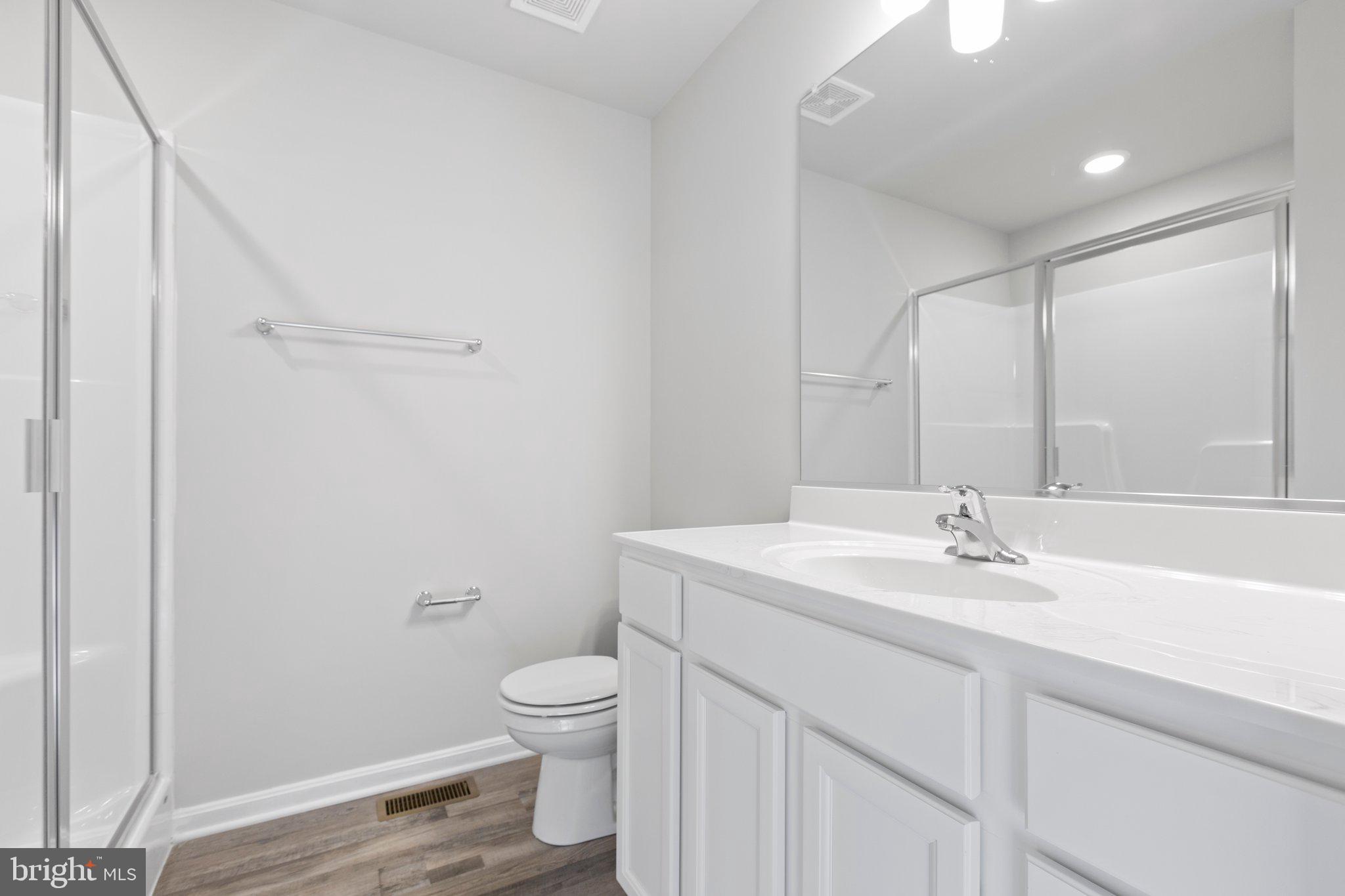 69 Pinewood Lane, Unit L18 Colonial Beach, VA 22443 - Photo 13 of 28 a bathroom with a sink a toilet and a mirror