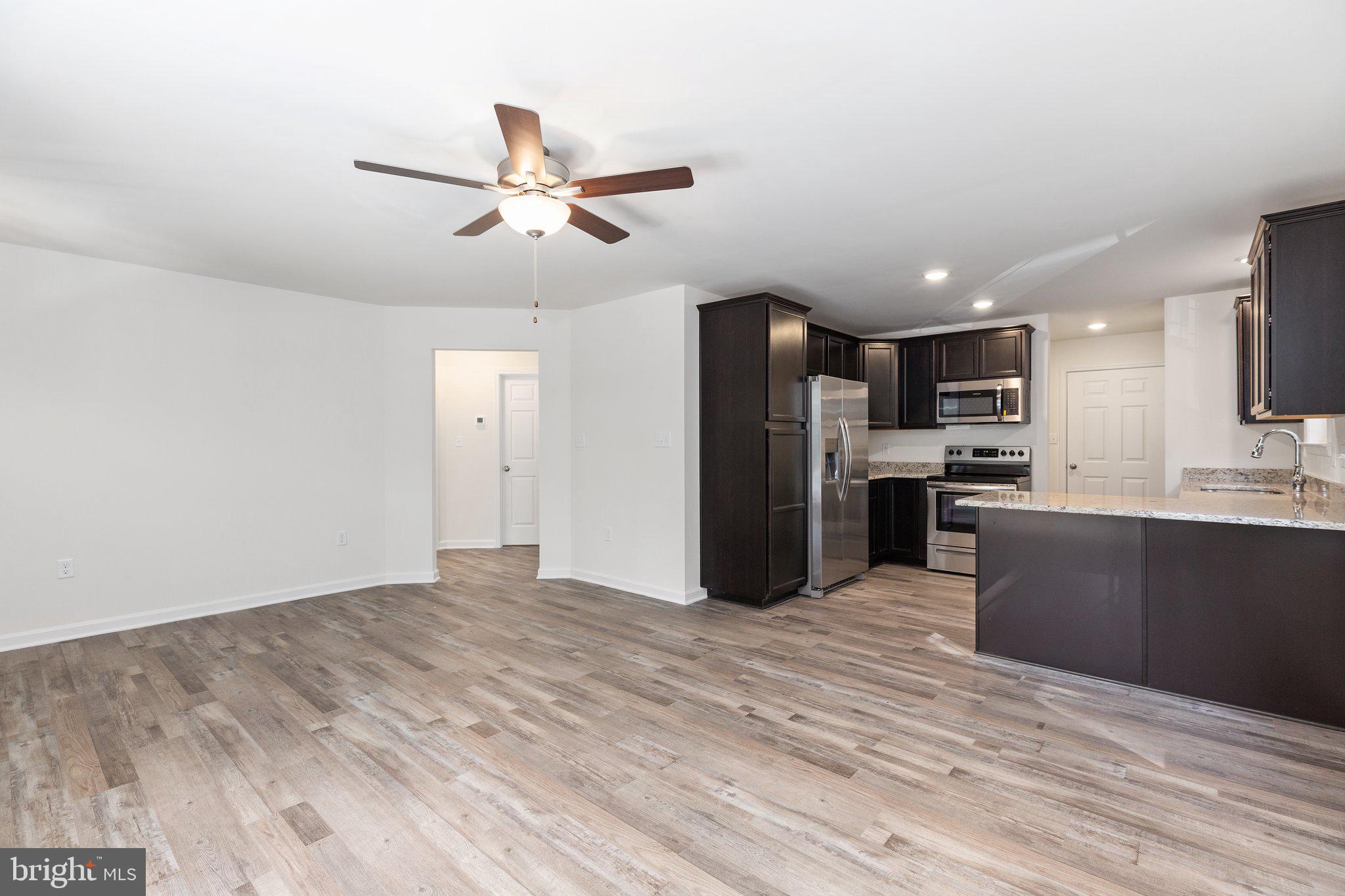 69 Pinewood Lane, Unit L18 Colonial Beach, VA 22443 - Photo 4 of 28 a kitchen with stainless steel appliances kitchen island granite countertop a refrigerator and a sink