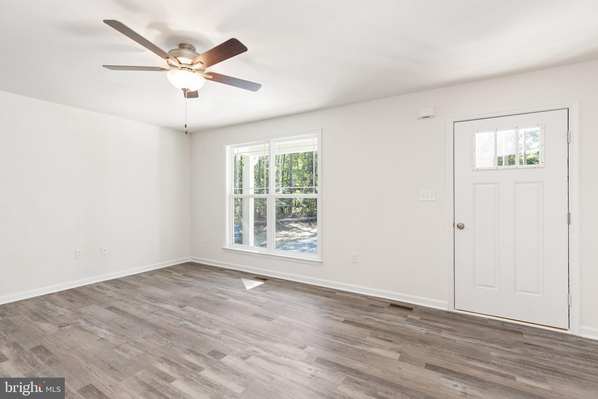 69 Pinewood Lane, Unit L18 Colonial Beach, VA 22443 - Photo 5 of 28 a view of an empty room with wooden floor and a window