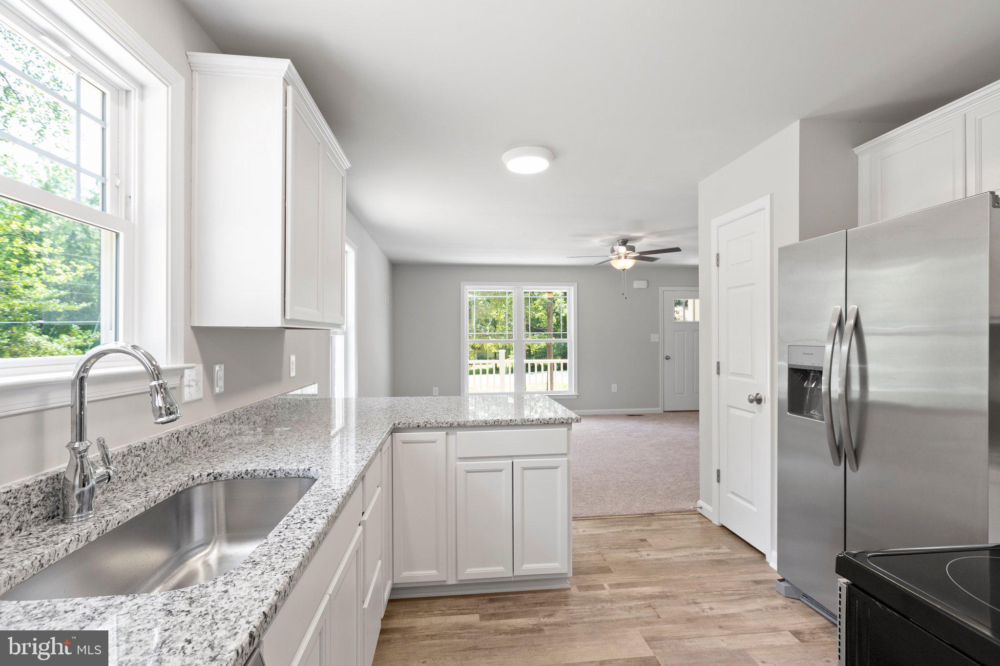 69 Pinewood Lane, Unit L18 Colonial Beach, VA 22443 - Photo 7 of 28 a large kitchen with granite countertop a sink stainless steel appliances and cabinets