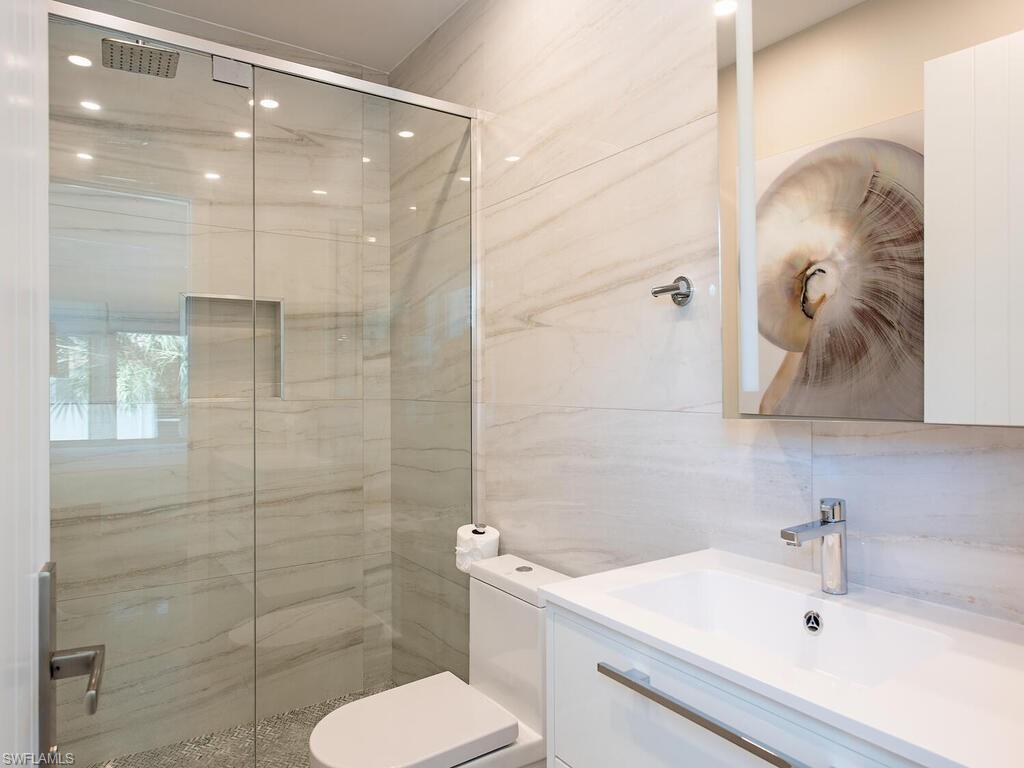536 2nd Street South, Unit 536 Naples, FL 34102 - Photo 7 of 14 Full bath featuring a marble finish shower, vanity, and tile walls