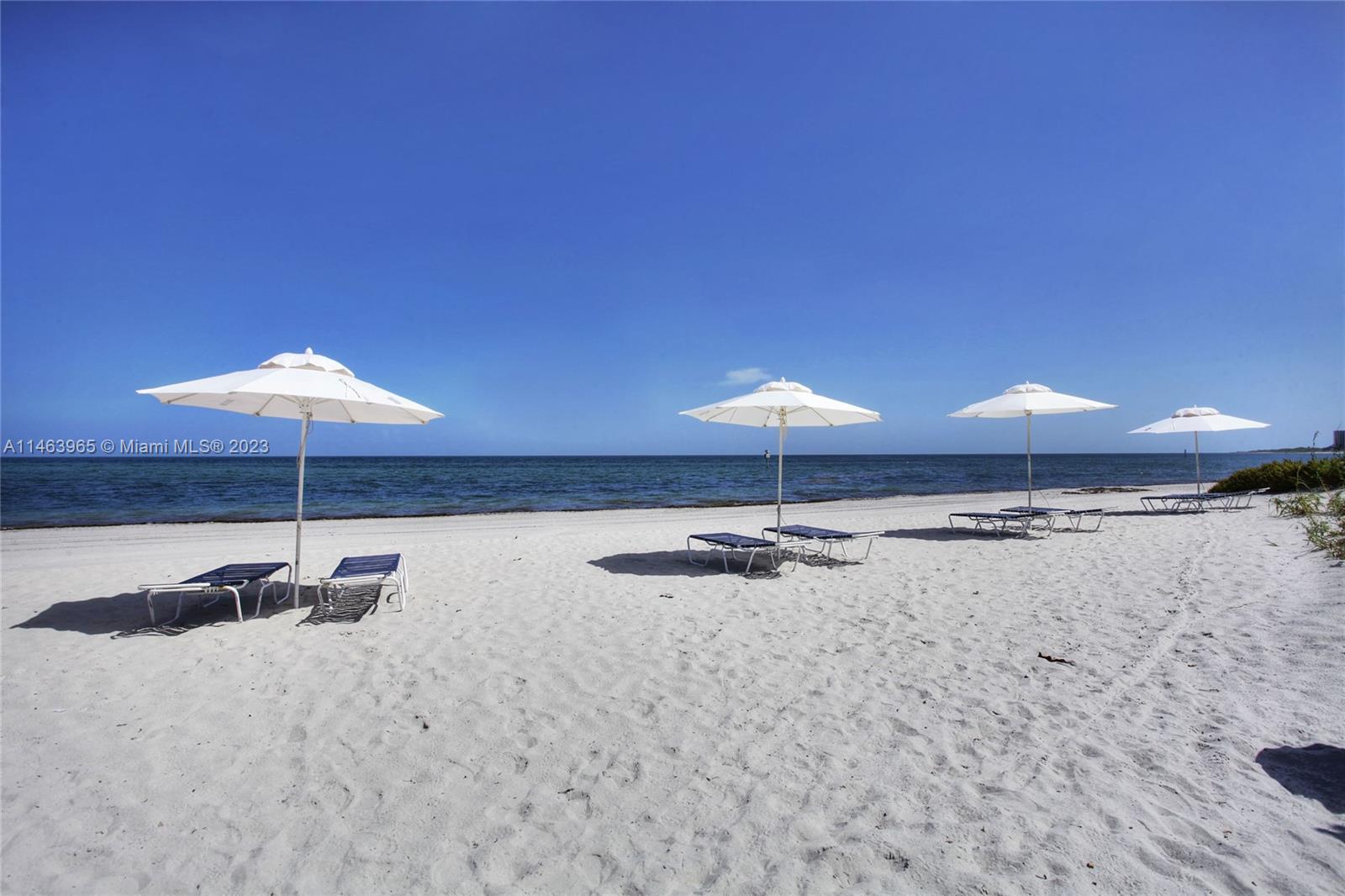 200 Ocean Ln Drive, Unit 703 Key Biscayne, FL 33149 - Photo 20 of 26 a room with a table and chairs under an umbrella