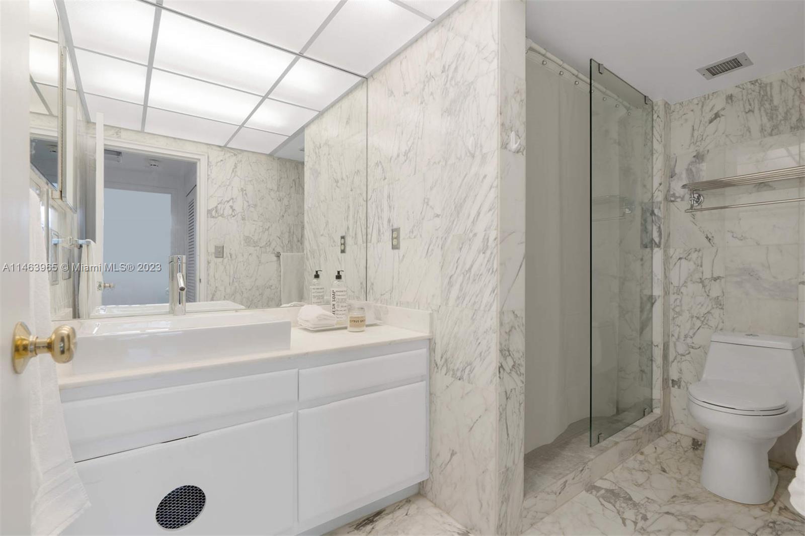 200 Ocean Ln Drive, Unit 703 Key Biscayne, FL 33149 - Photo 9 of 26 a bathroom with a sink a toilet a mirror a vanity and shower