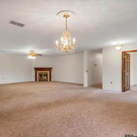 a view of an empty room with a window and a kitchen