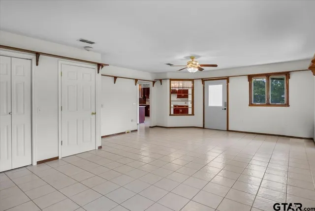 a white house with a big yard and large trees
