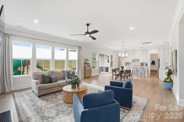 a living room with furniture a fireplace and a chandelier
