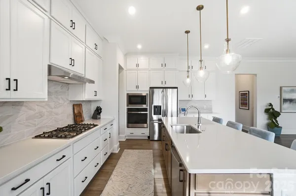 a storage room with stainless steel appliances granite countertop lots of clutter and cabinets