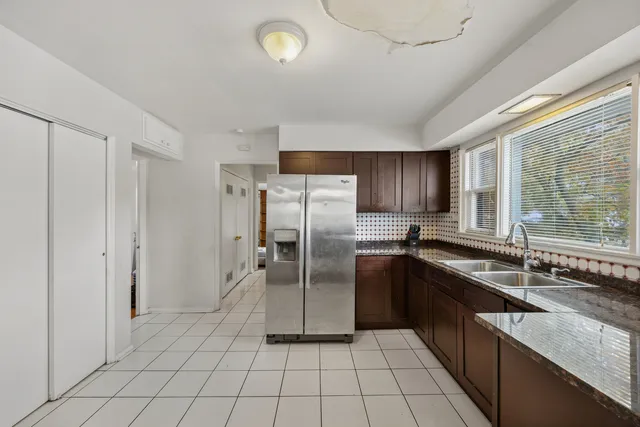 a kitchen with granite countertop a refrigerator and a sink