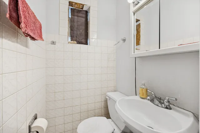 a bathroom with a sink mirror and toilet