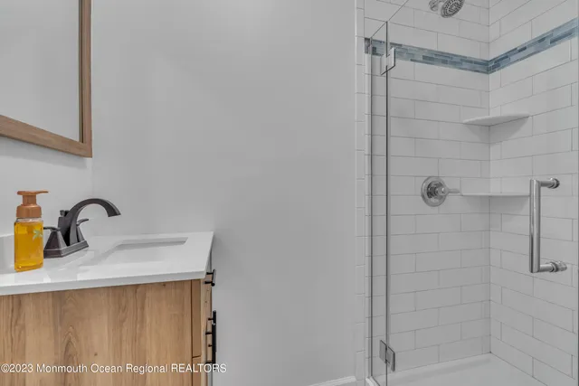a bathroom with a sink shower and a mirror