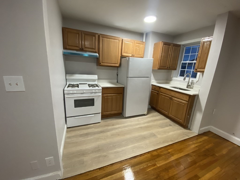 a kitchen with refrigerator cabinets and wooden floor