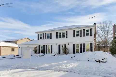 a view of a white house with a large windows in front of it