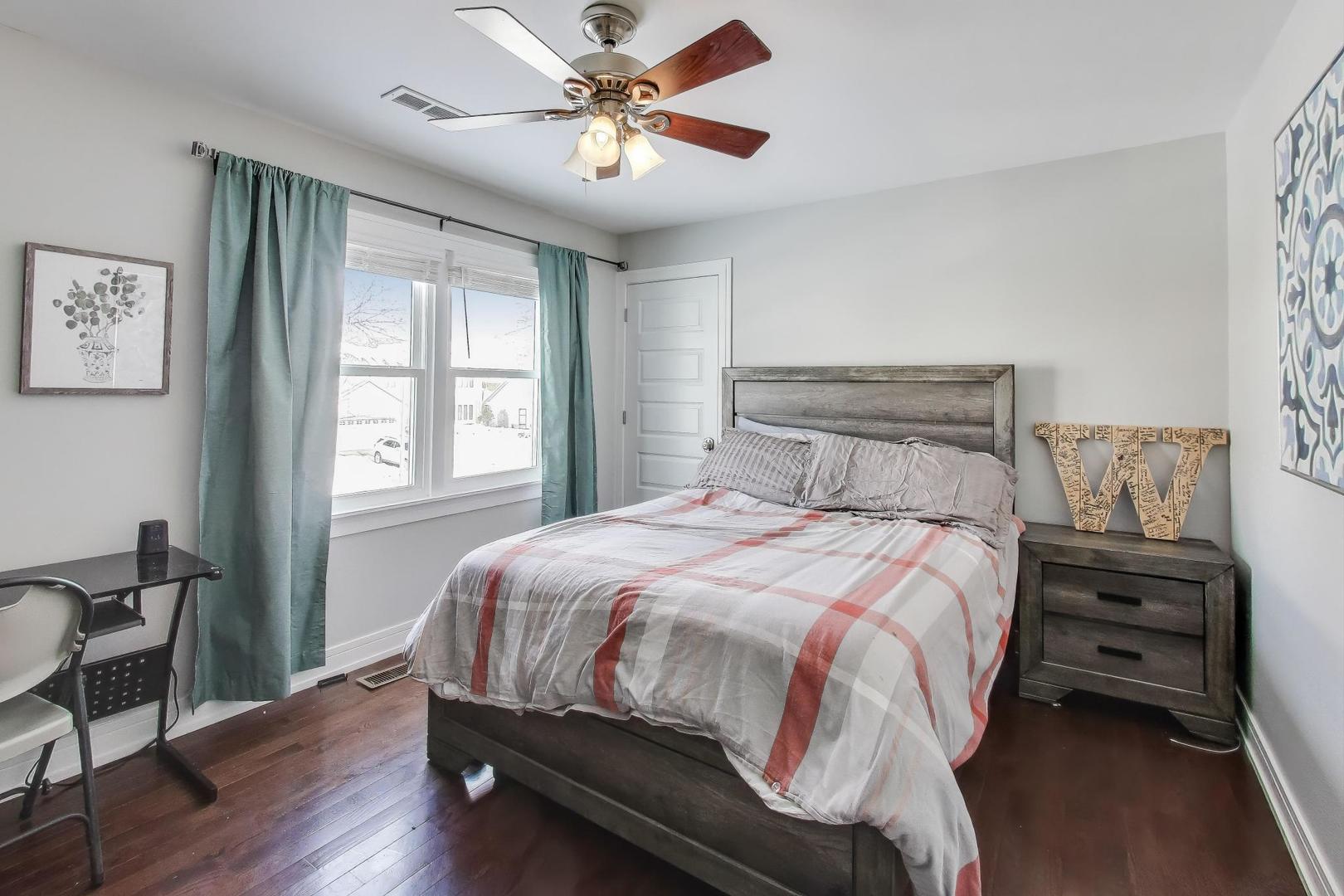 1565 Brittany Lane Hoffman Estates, IL 60192 - Photo 15 of 26 a bedroom with a bed a dresser and a window