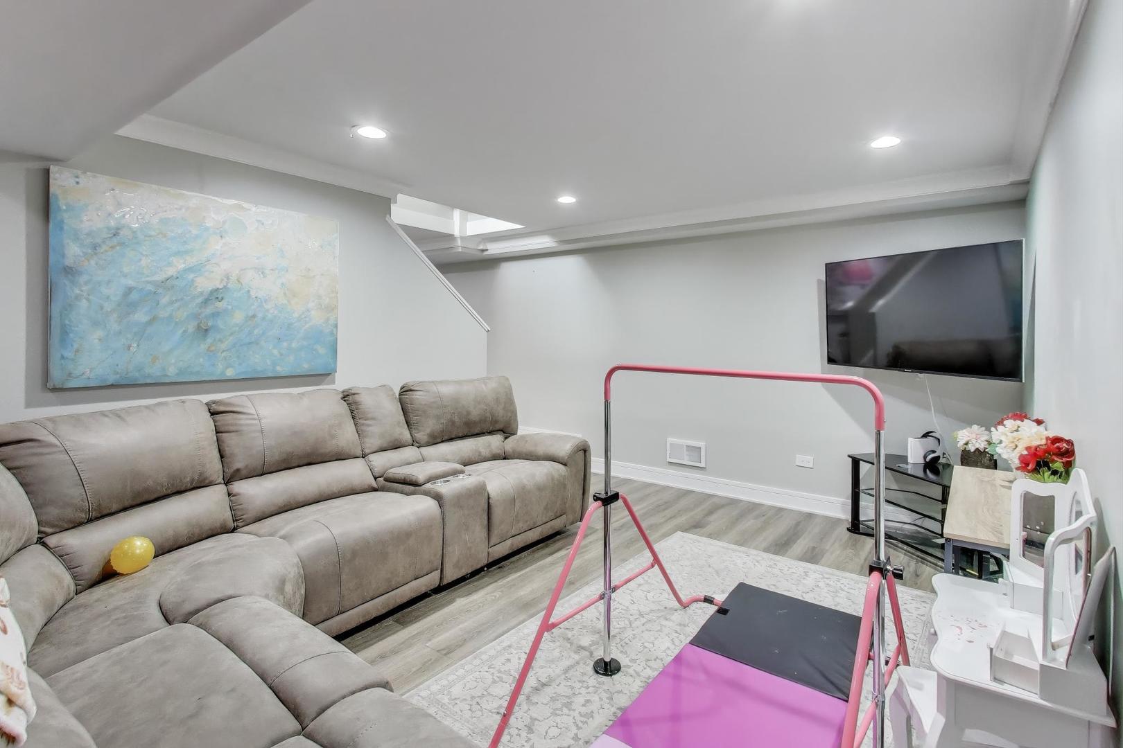 1565 Brittany Lane Hoffman Estates, IL 60192 - Photo 19 of 26 a living room with furniture and a flat screen tv