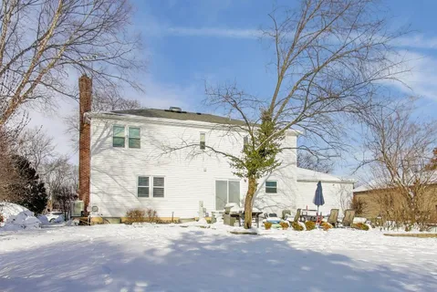 a front view of a building with large trees