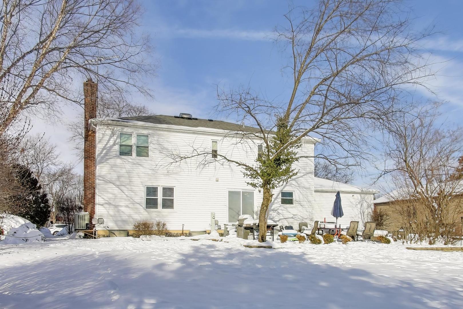 1565 Brittany Lane Hoffman Estates, IL 60192 - Photo 21 of 26 a front view of a building with large trees