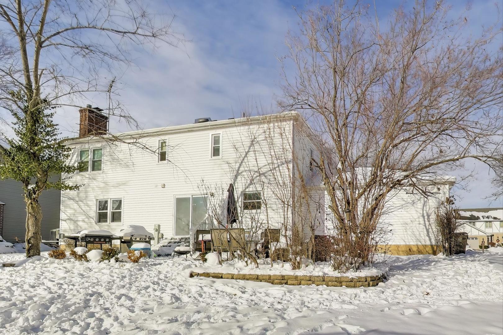 1565 Brittany Lane Hoffman Estates, IL 60192 - Photo 23 of 26 a front view of a building with large trees