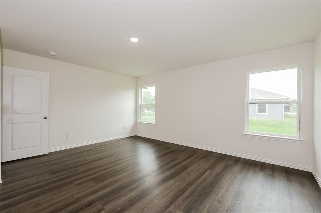 417 Shorty Street Mabank, TX 75147 - Photo 11 of 20 an empty room with wooden floor and windows
