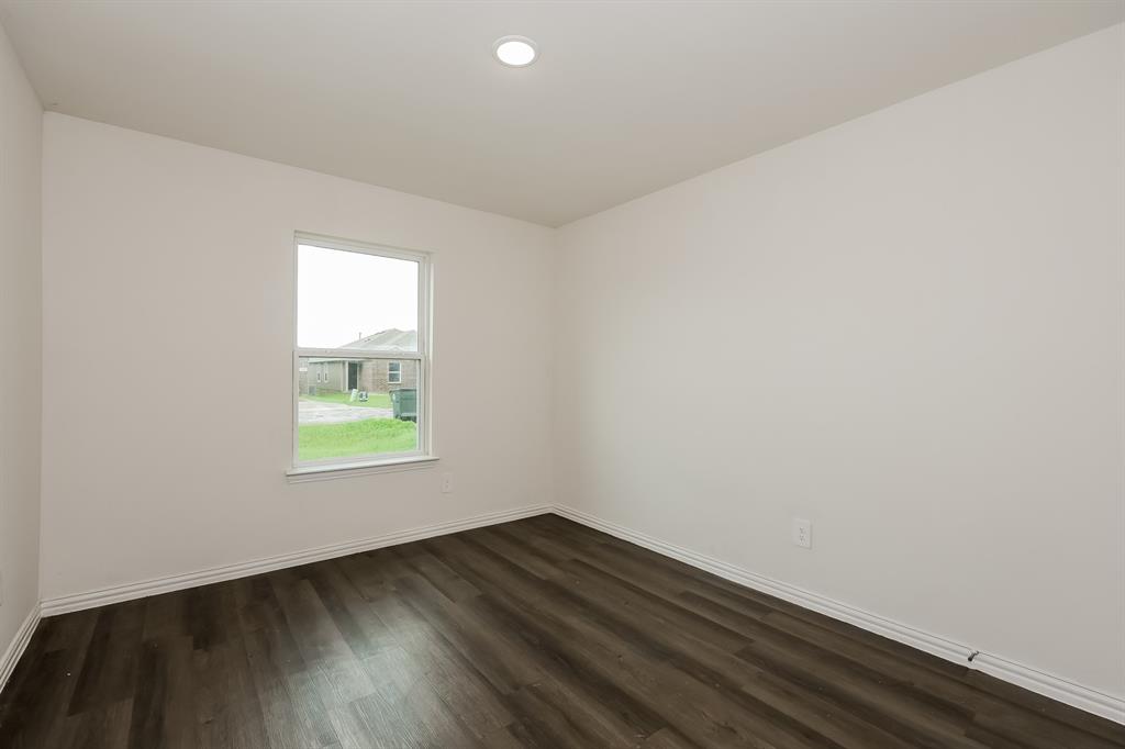 417 Shorty Street Mabank, TX 75147 - Photo 14 of 20 an empty room with wooden floor and a window
