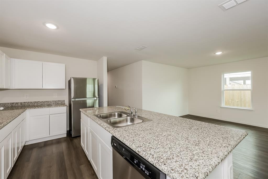 417 Shorty Street Mabank, TX 75147 - Photo 8 of 20 a kitchen with a granite countertop sink stove and refrigerator