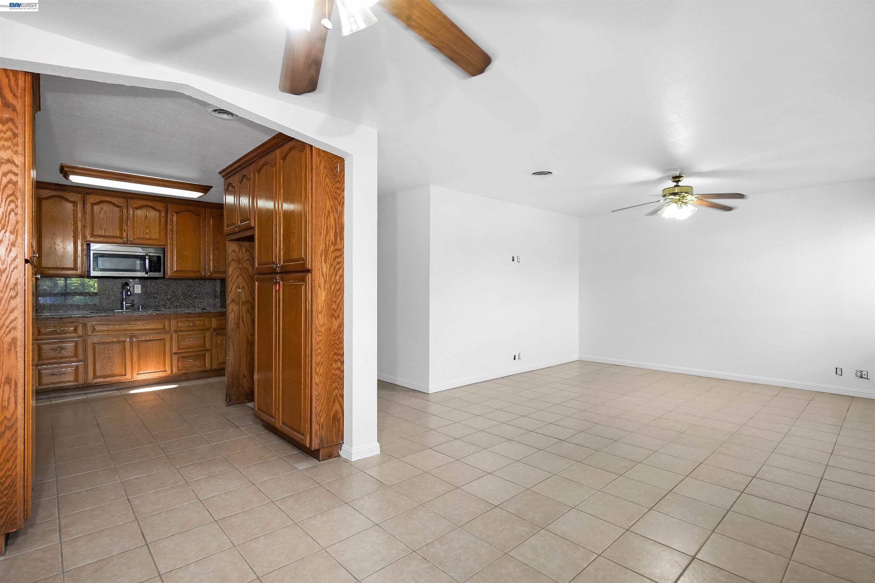 387 Tennyson Road Hayward, CA 94544 - Photo 17 of 48 a kitchen with granite countertop a refrigerator and a stove top oven