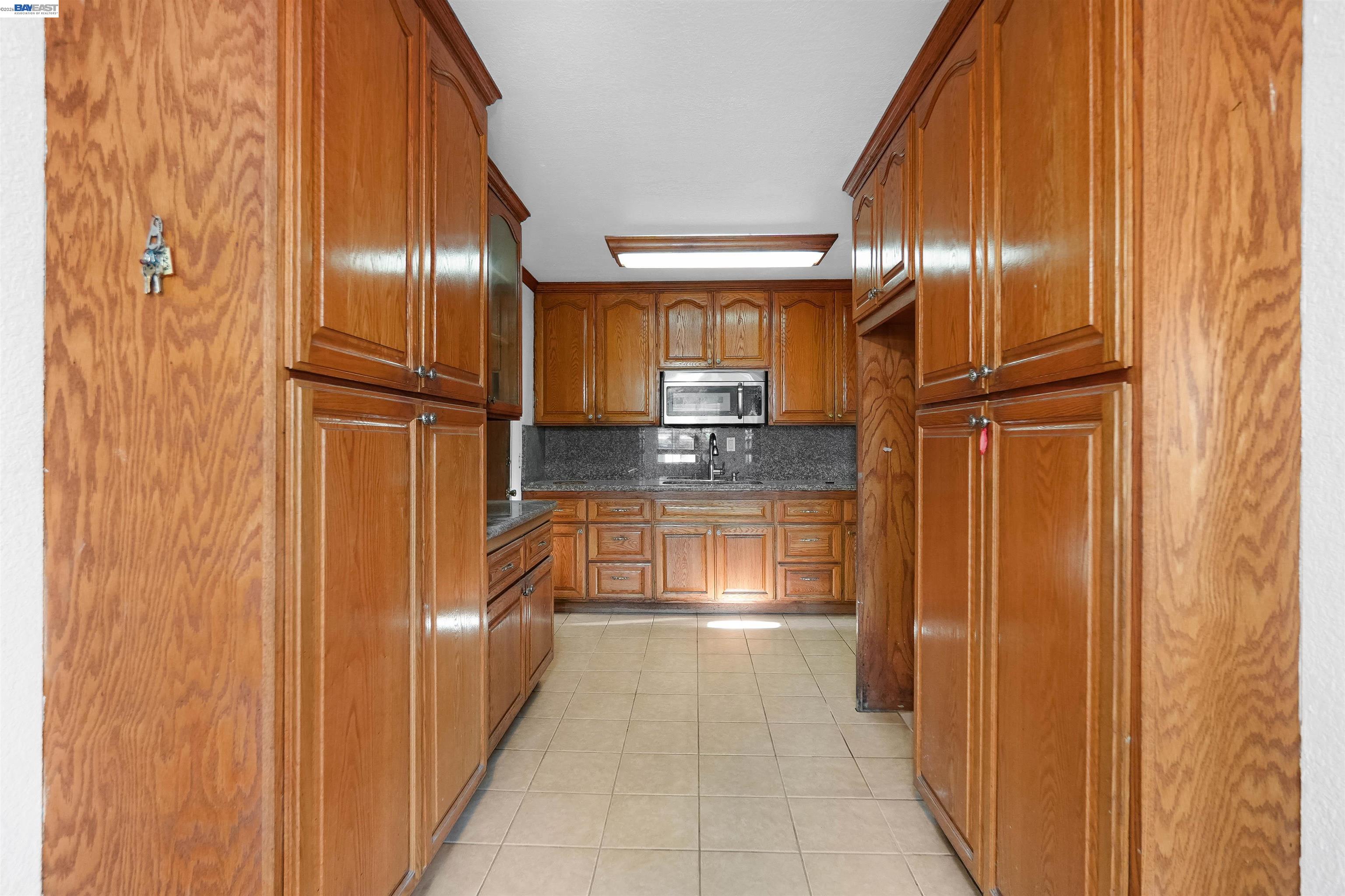 387 Tennyson Road Hayward, CA 94544 - Photo 18 of 48 a kitchen with granite countertop stainless steel appliances a refrigerator and cabinets
