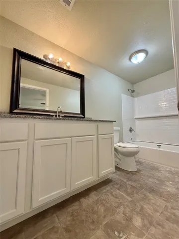 a spacious bathroom with a toilet sink and mirror