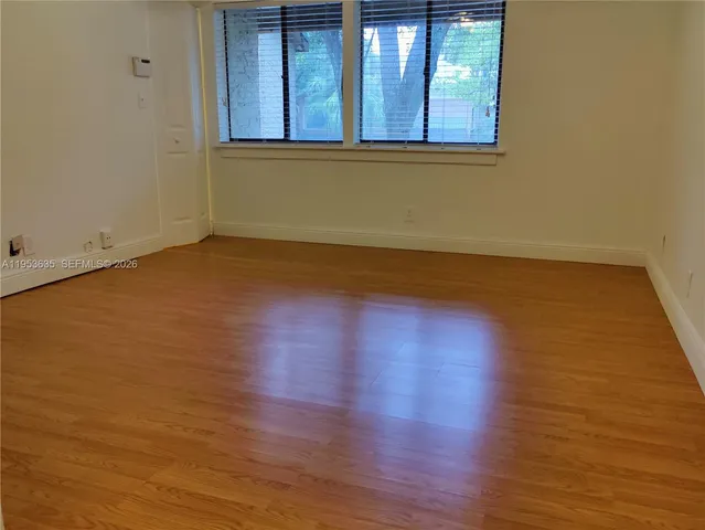 a view of a room with wooden floor and a window