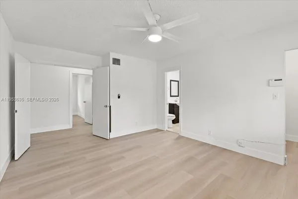 an empty room with fan and entrance