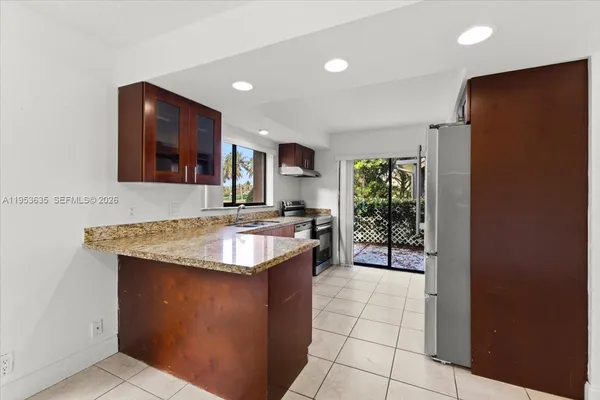 a kitchen with stainless steel appliances granite countertop a sink stove and a refrigerator