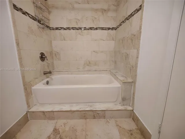 a white bath tub sitting next to a shower
