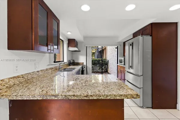 a kitchen with stainless steel appliances granite countertop a sink refrigerator and microwave