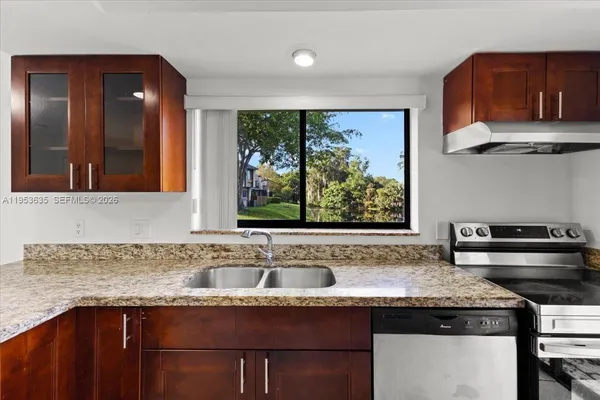 a kitchen with granite countertop a sink and a stove