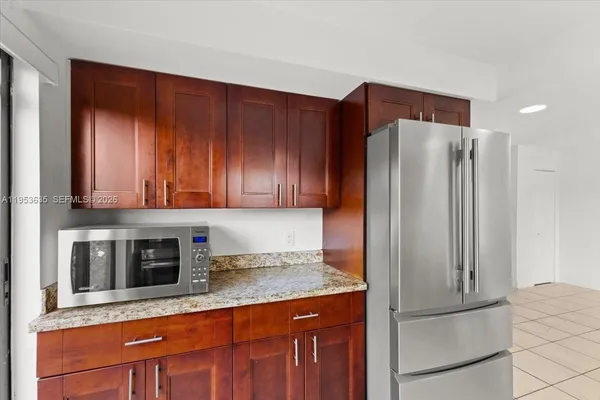 a kitchen with stainless steel appliances granite countertop a refrigerator and a stove top oven
