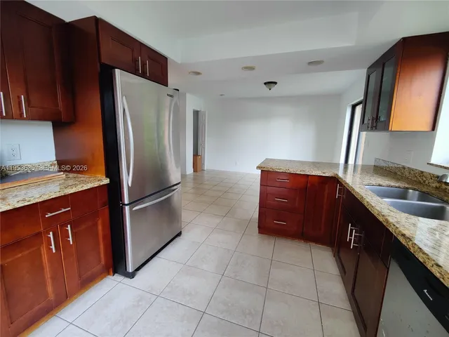a kitchen with stainless steel appliances granite countertop a refrigerator and a sink