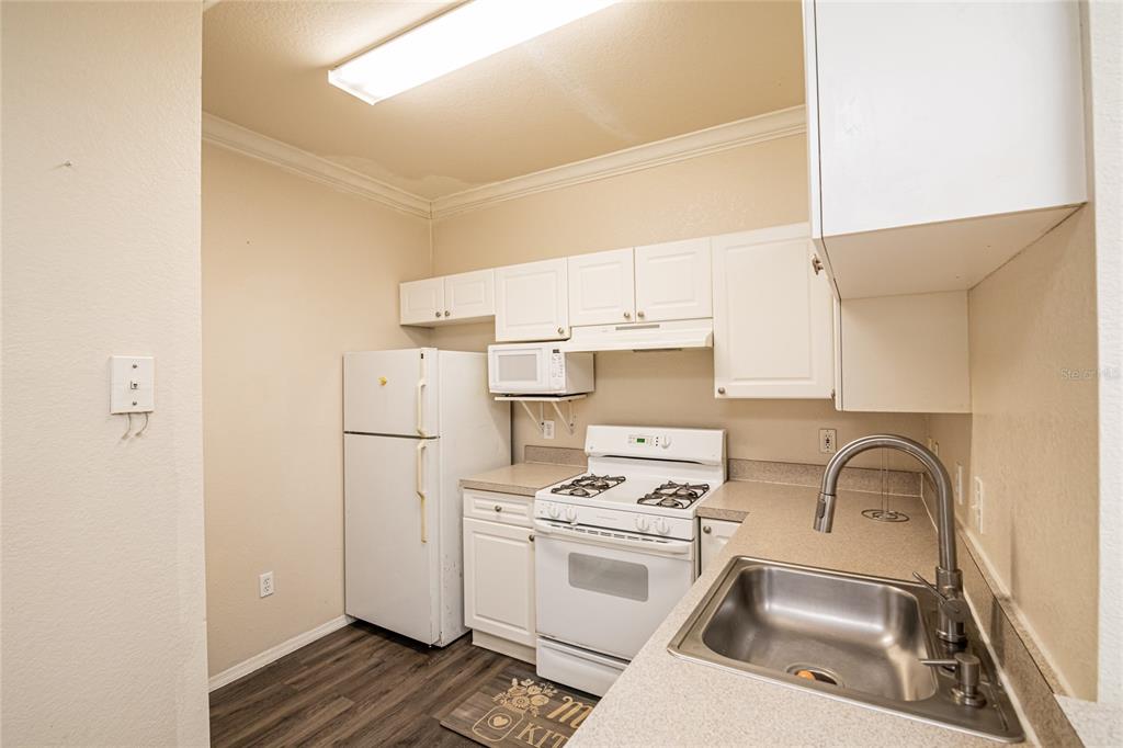 3391 South Kirkman Road, Unit 1216 Orlando, FL 32811 - Photo 8 of 33 a kitchen with a refrigerator sink and white cabinets