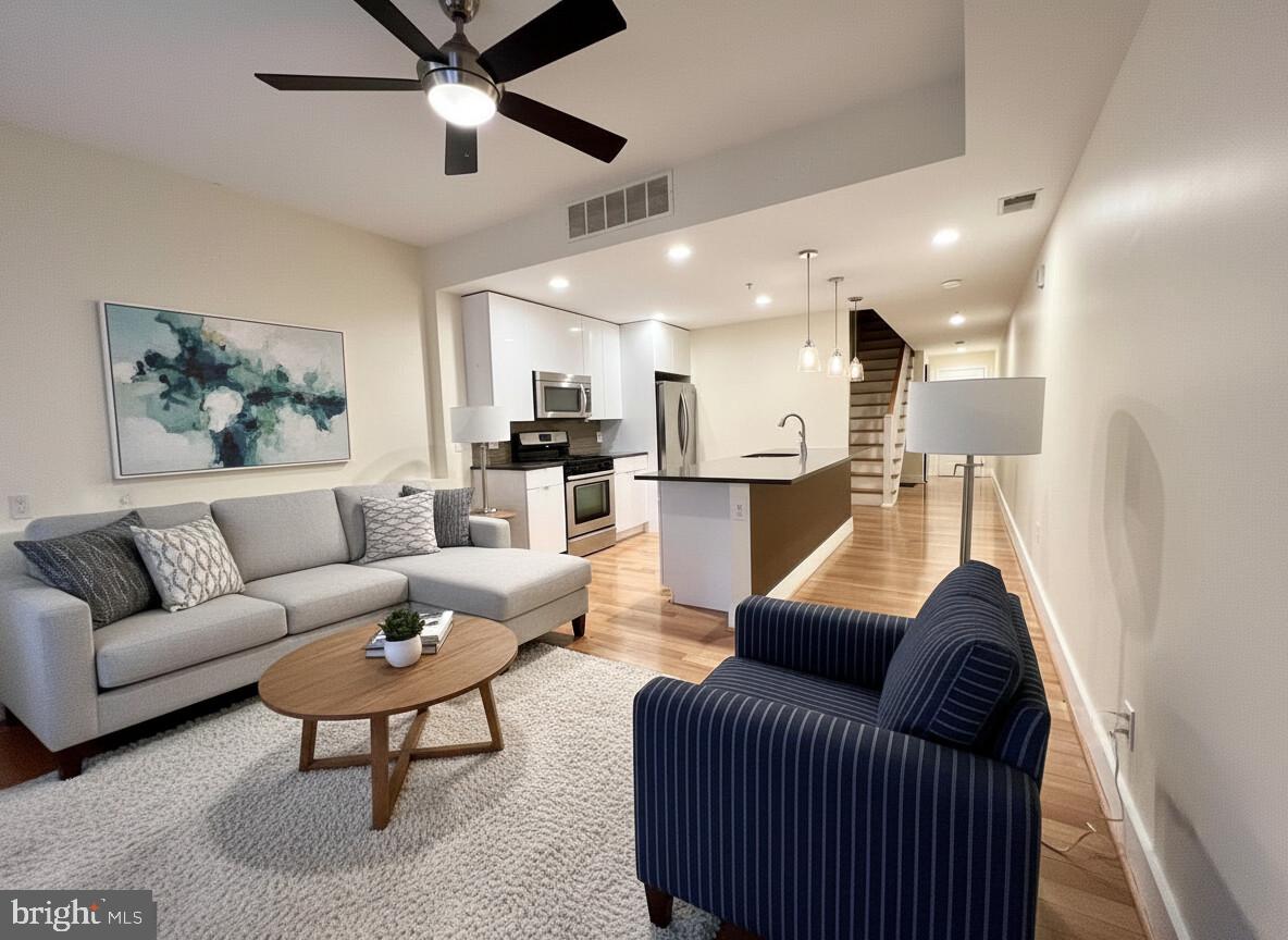 a living room with furniture and a ceiling fan