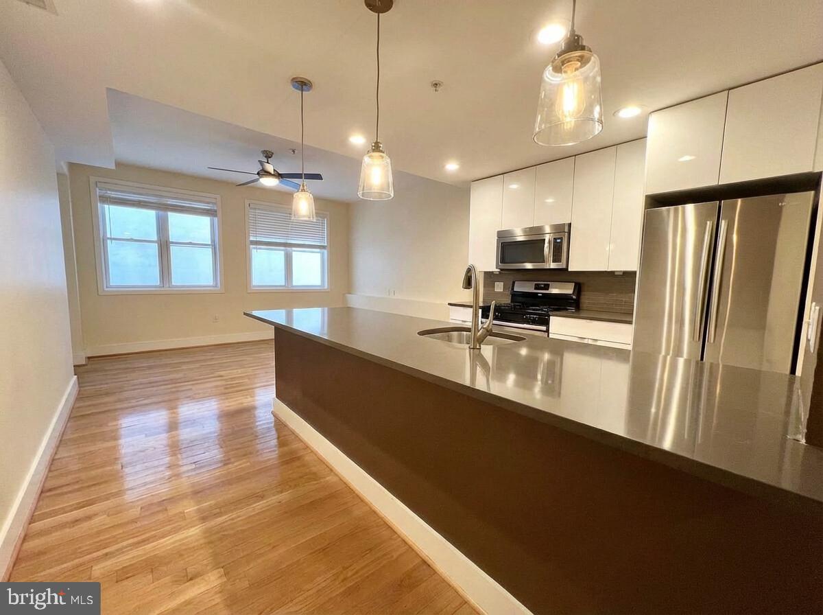 112 Market Street, Unit 4 Philadelphia, PA 19106 - Photo 3 of 15 a large kitchen with kitchen island a counter space a sink and appliances