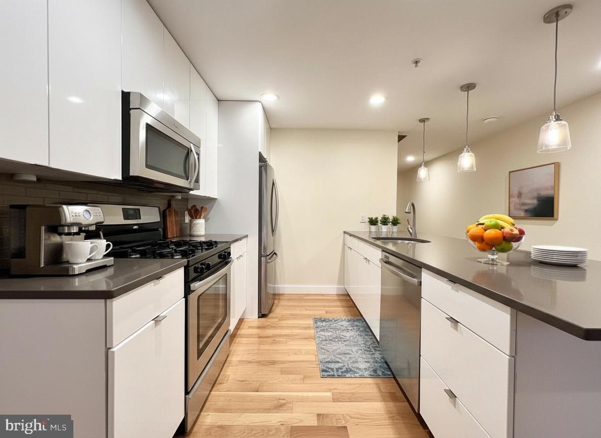 112 Market Street, Unit 4 Philadelphia, PA 19106 - Photo 4 of 15 a kitchen with stainless steel appliances granite countertop a sink a stove and cabinets