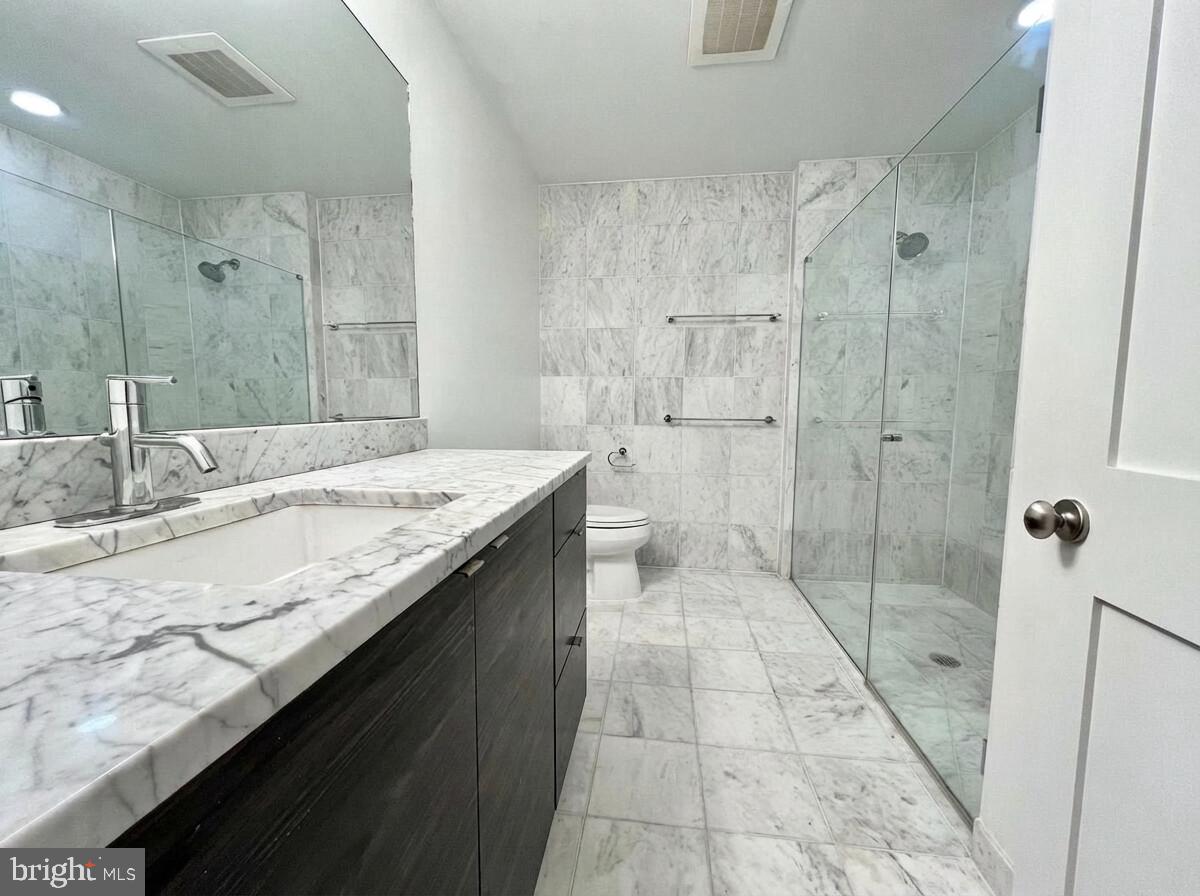 112 Market Street, Unit 4 Philadelphia, PA 19106 - Photo 8 of 15 a bathroom with a granite countertop sink a toilet and shower