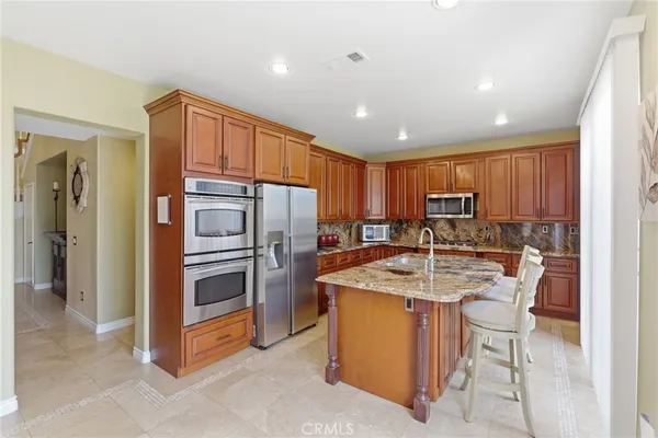 a kitchen with stainless steel appliances granite countertop a sink dishwasher and cabinets with wooden floor
